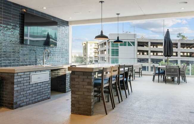 A modern bar area with a television and a view of the city.