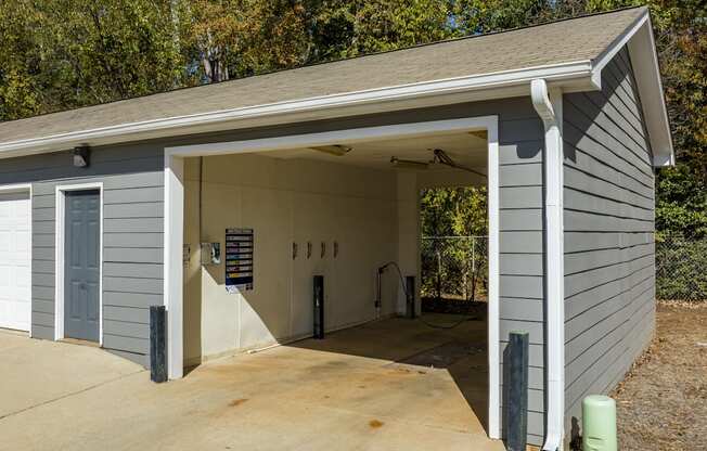 A garage with a grey siding and a white door is shown.