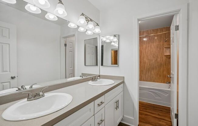 A bathroom with a white sink and brown countertop.