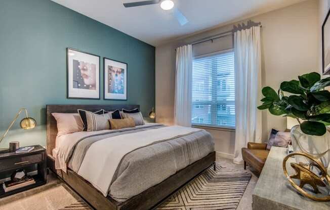 A bedroom with a large bed and a ceiling fan.