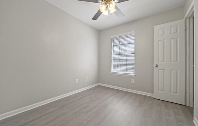 a bedroom with hardwood floors and a ceiling fan