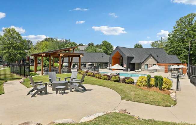 A sunny day at a poolside area with a pavilion and chairs.