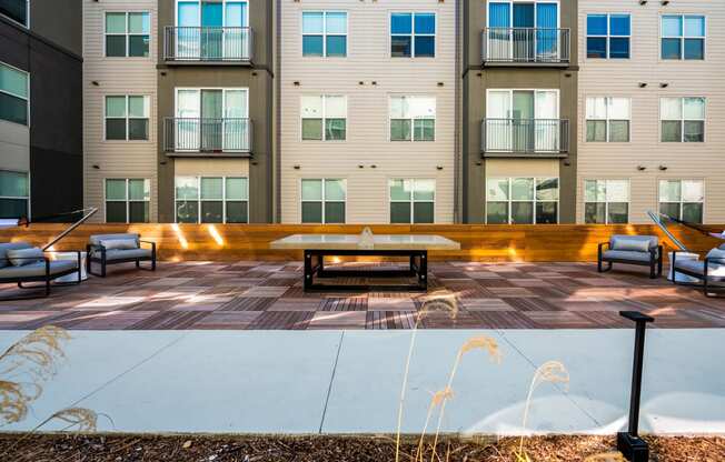 an empty patio with a table and chairs in front of an apartment building at Mockingbird Flats, Dallas, 75206