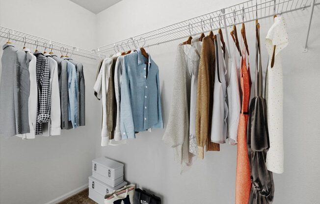 a closet with clothes hanging on a rack