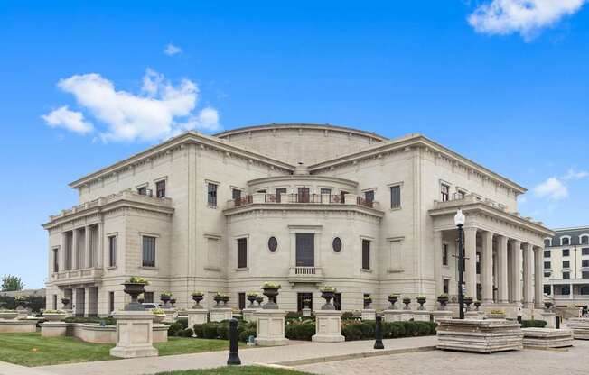 a large white building with columns and a dome with a blue sky in the background