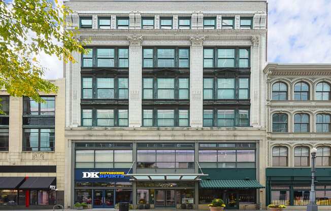 exterior of multi-story building from street view with retail stores on street level