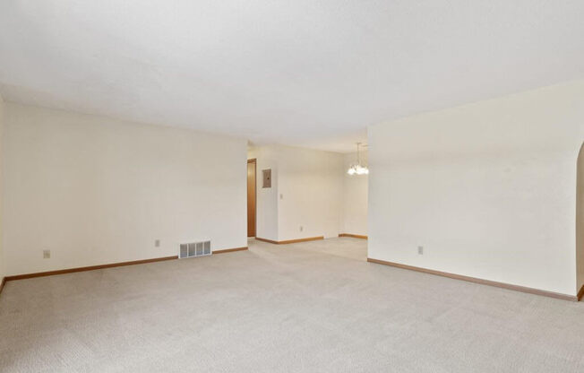 apartment living room with white walls and carpet