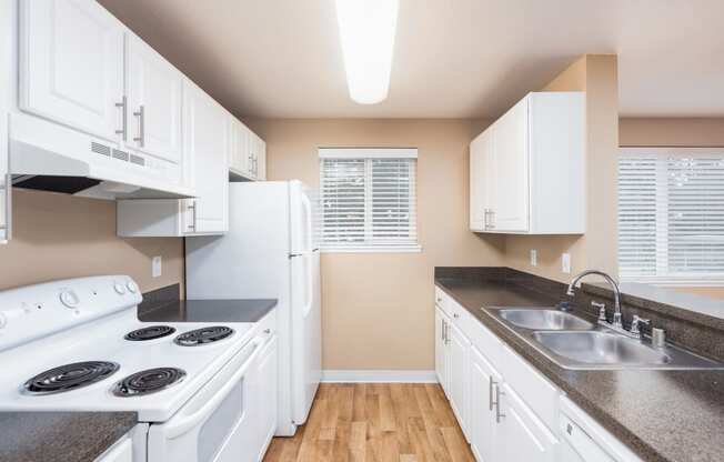 a kitchen with white appliances and counter tops and a sink