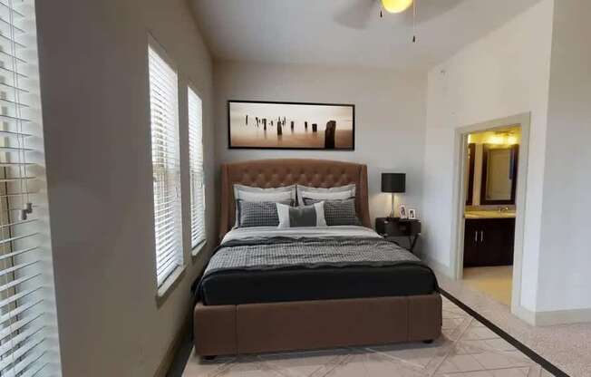 A bedroom with a large bed and a painting on the wall.