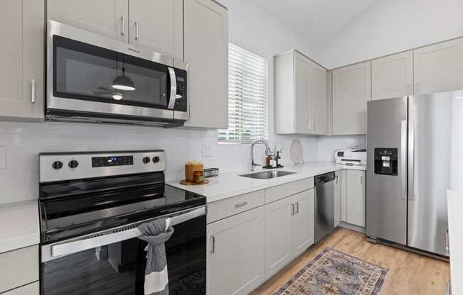 a kitchen with stainless steel appliances and white cabinets