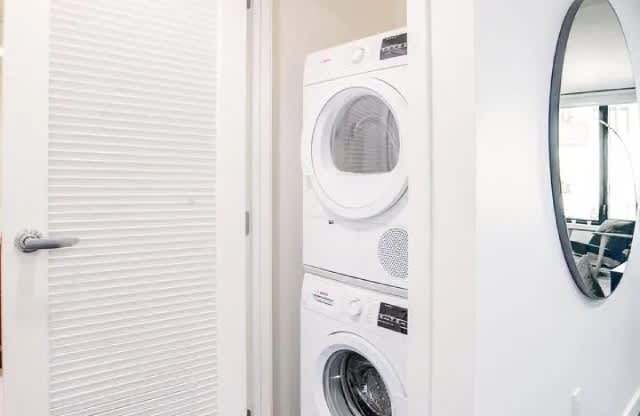 A white door with a white washing machine behind it.