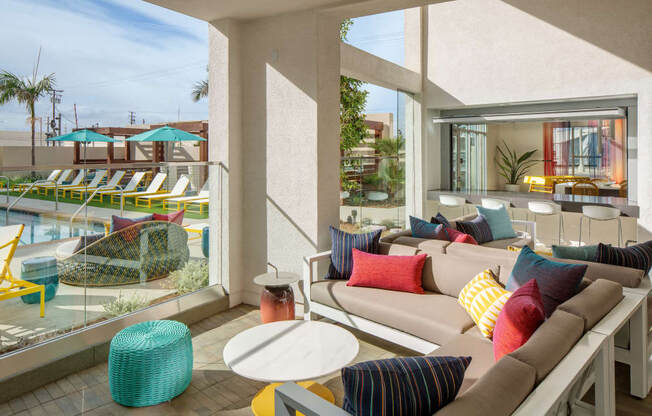 A sunny day at the poolside with a comfortable seating area.