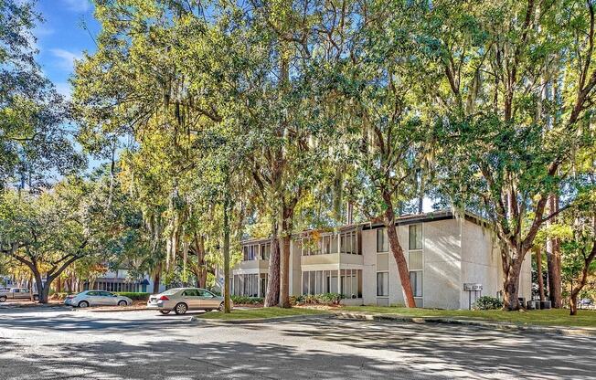 Greentree Apartments in Savannah, GA photo of a building with trees and cars parked in front of it