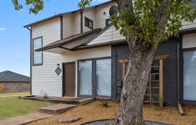 a white and black house with a tree in front of it at Diamond Ridge Townhomes, Oklahoma City, OK