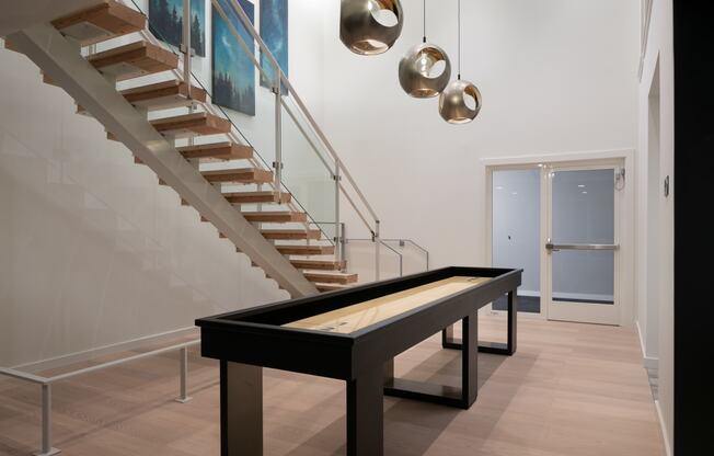 a ping pong table in a living room next to stairs