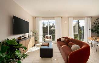 A living room with a red couch and a flat screen TV.