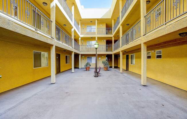 a courtyard with a lamp in the middle of a yellow building