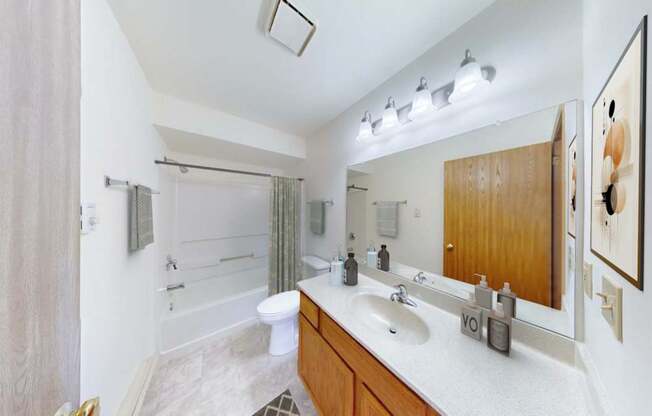 A bathroom with a white counter top and a white sink.
