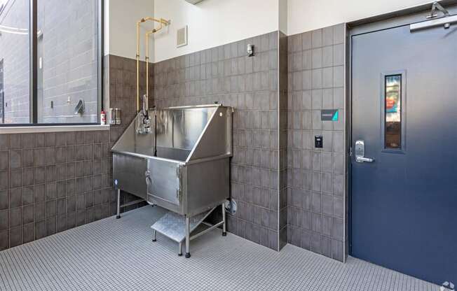 a bathroom with a stainless steel sink and a door