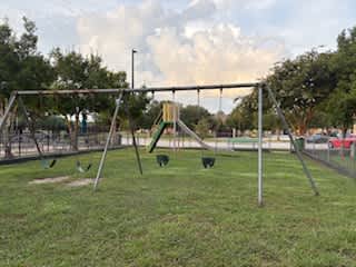 A playground with a swing set and a slide.