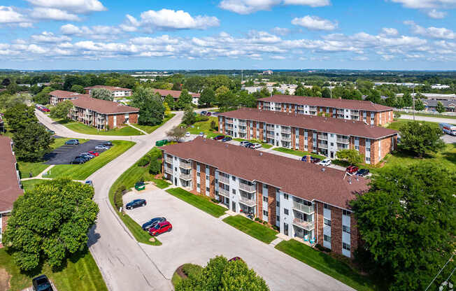 A large apartment complex with a parking lot in front.