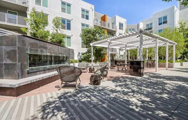 a patio with awnings and benches in front of an apartment building