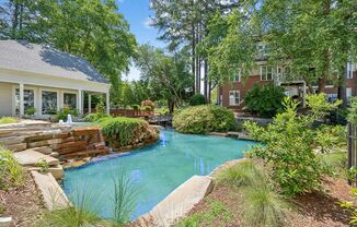 a swimming pool with a waterfall in front of a house