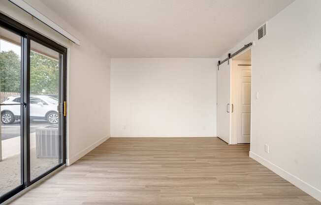 a bedroom with a sliding glass door and hardwood floors