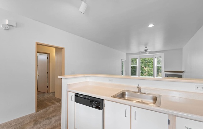 a kitchen with white cabinets and a sink and a window