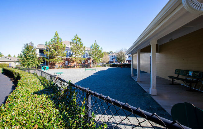 a patio with a chain link fence and a playground