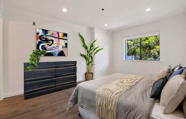 a bedroom with a bed and a dresser in front of a window  at Masselin Park West, Los Angeles, 90036