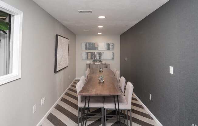 a dining room with a long wooden table and white chairs
