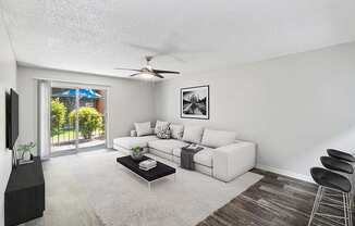 Model Living Room with Wood-Style Flooring and Patio Accessibility at Indigo Park Apartments located in Albuquerque, NM.