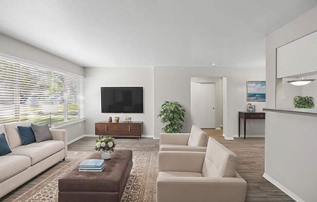 A living room with a couch, a coffee table, and a television.