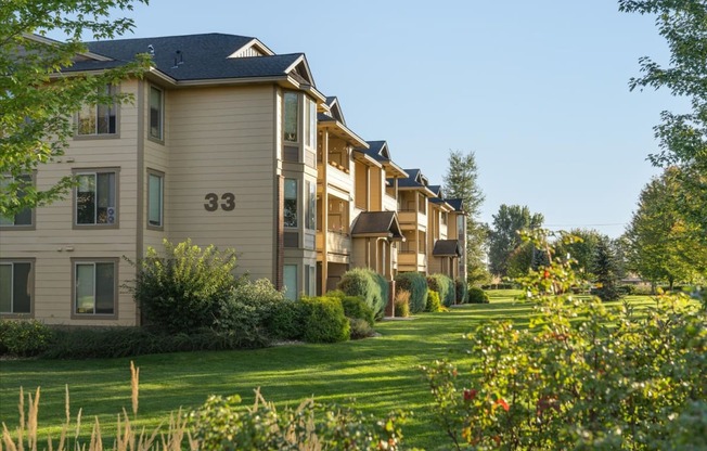 a row of townhomes with grass and trees