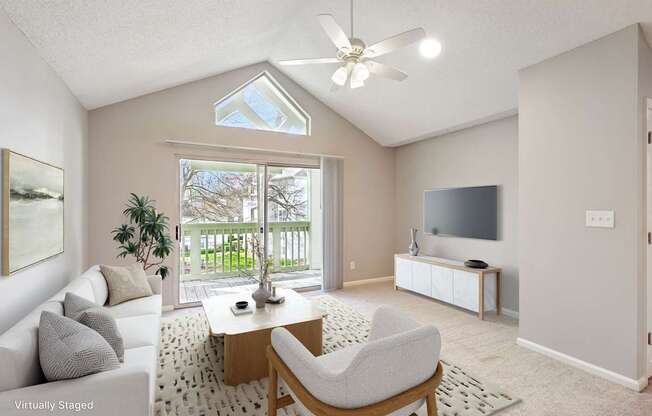 A living room with a white couch, a wooden coffee table, and a ceiling fan.