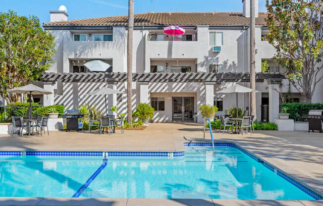 a swimming pool in front of a white building with a pool