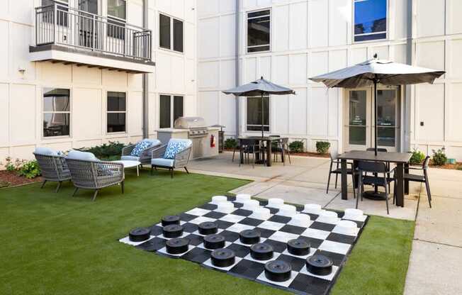 A checkerboard is on the lawn in front of a building.