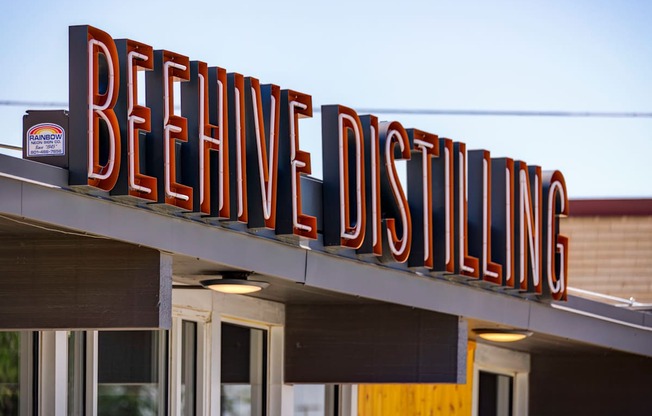 A sign for BeeHive Distilling is displayed on a building.