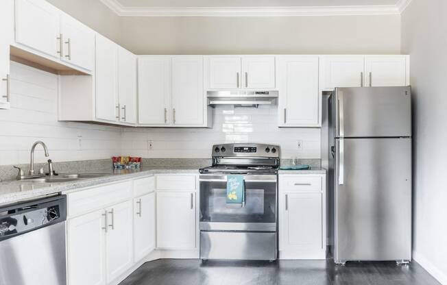 Affordable Houston Texas Apartments – Westchase Forest – Photo of upgraded kitchen with white cabinets and stainless steel appliances