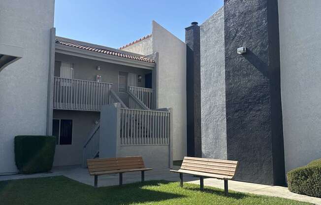 a courtyard with two benches in front of a building