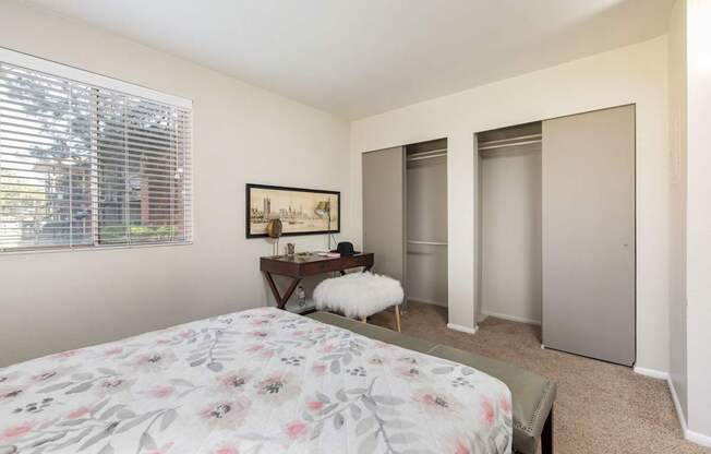 a bedroom with a bed and two closets and a window
