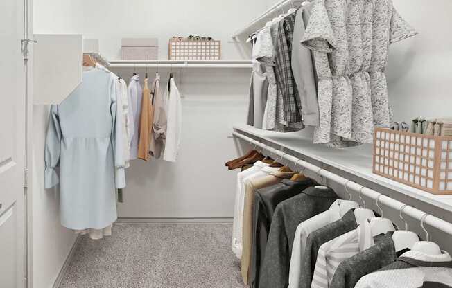 A white closet with clothes hanging and shelves with boxes.