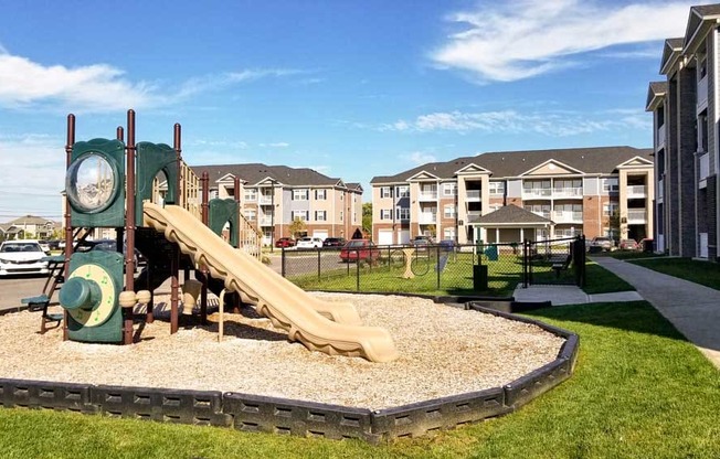 Playground with a slide and clock in front of Mosaic Apartments in Avon, Indiana