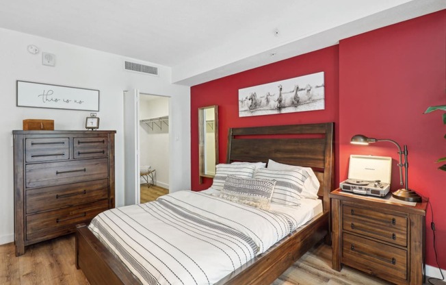 a bedroom with a bed and red walls and wooden furniture
