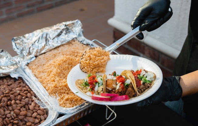 a person holding a plate of food on a food cart