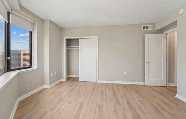 A large beroom with luxury plank flooring and spacious closet