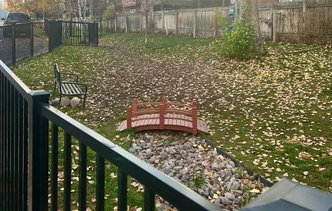 Fenced in dog park with a bridge in the middle
