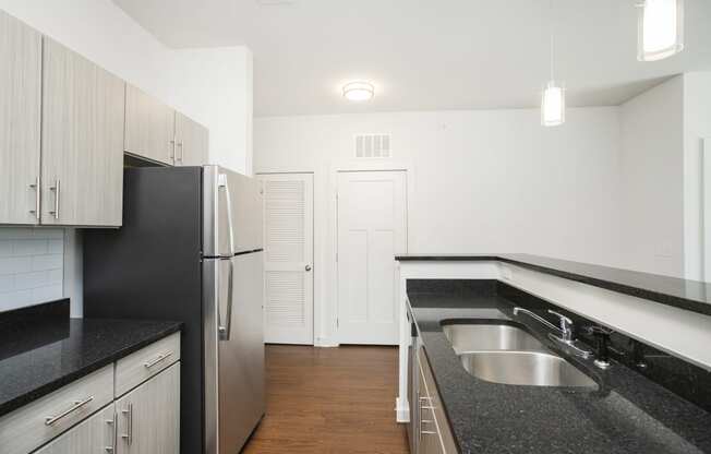 a kitchen with black granite countertops and stainless steel appliances