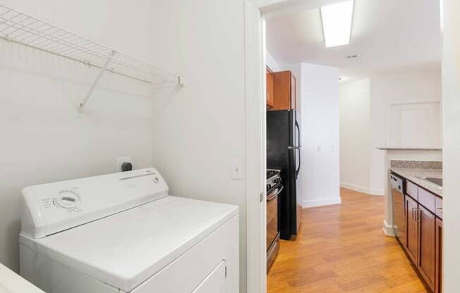 a white kitchen with a white washer and dryer in it